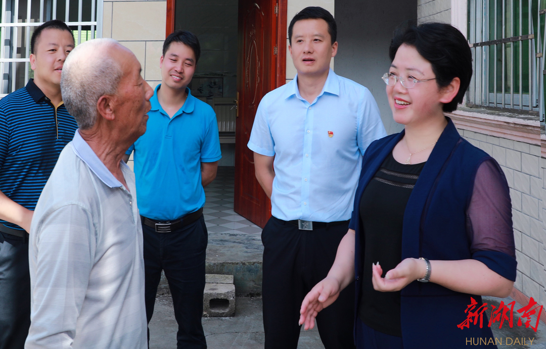 杨志慧(右一)与村民吴绍军亲切交谈