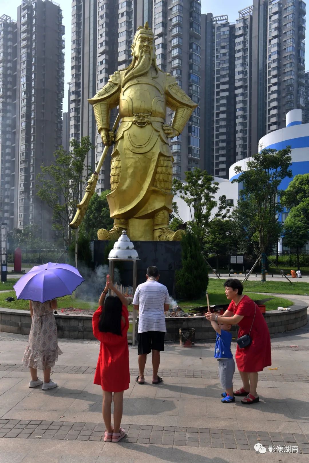 2020年7月14日,长沙市开福区湘江世纪城,市民在关公雕像前叩拜.