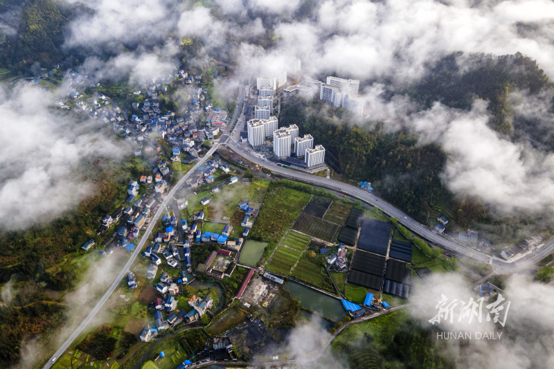 3月22日,吉首市乾州街道三岔坪村附近云雾缭绕,山峰,森林和建筑物在