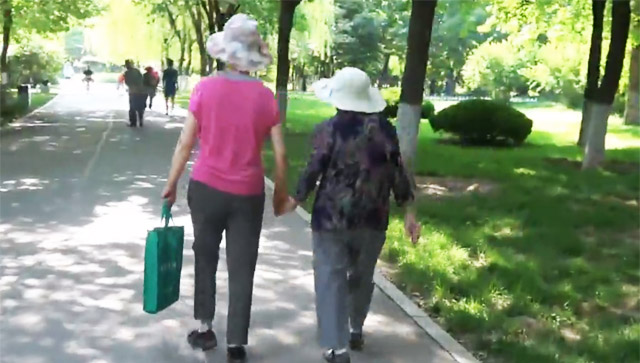 暖！68岁女儿手牵90岁母亲逛公园 牵手怕母亲摔倒