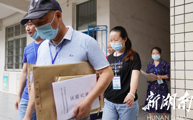 8点25分许,怀化市一中考点,监考老师领取试卷进入考场。【卢嘉俊 摄】 8点25分许,怀化市一中考点,监考老师领取试卷进入考场。【卢嘉俊 摄】