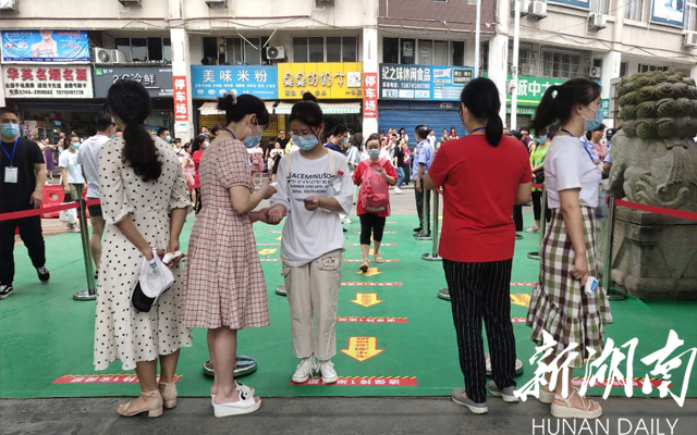 上午8时许, 怀化市铁路第一中学考点考生有序进入考场 ,工作人员现场测量体温。【李夏涛 摄】 上午8时许, 怀化市铁路第一中学考点考生有序进入考场 ,工作人员现场测量体温。【李夏涛 摄】