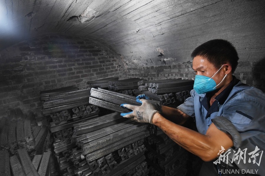 9月26日,炎陵县垄溪乡林龙炭业制品厂生产车间,工人将烧制完成的竹炭