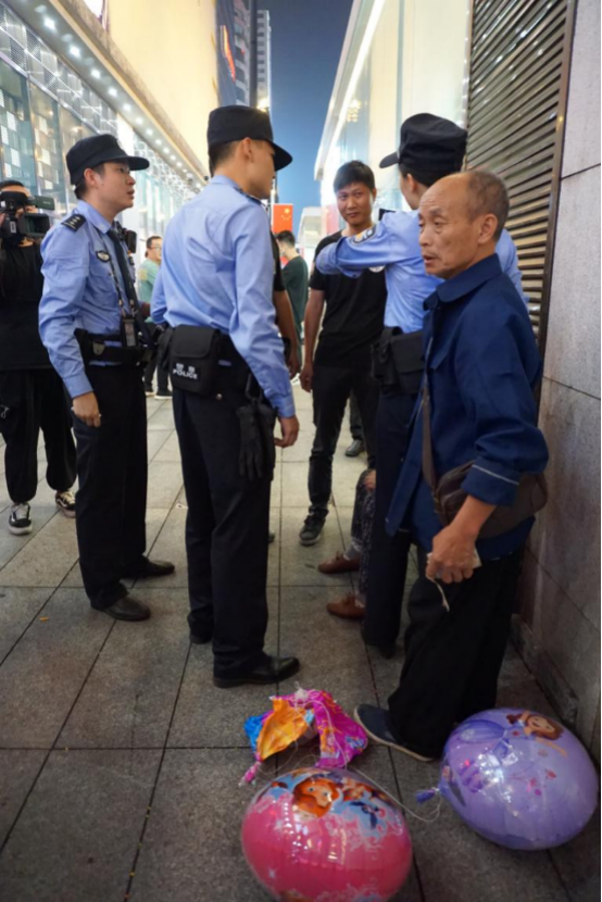 原来报警人是一对卖气球的外地老夫妇，他们声称和商圈保安发生了冲突，妻子被推搡受伤，情绪激动，双方僵持在现场。