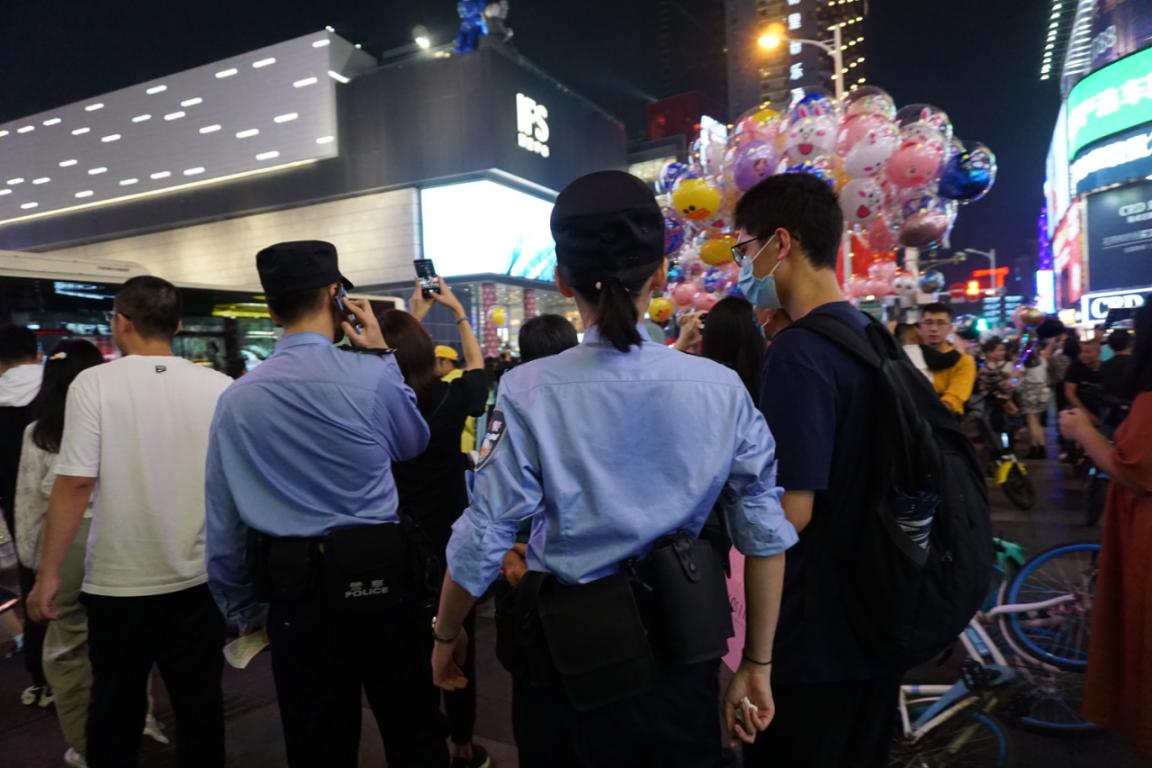 在拥挤的国金中心附近，民警们不停和报警市民确定位置。