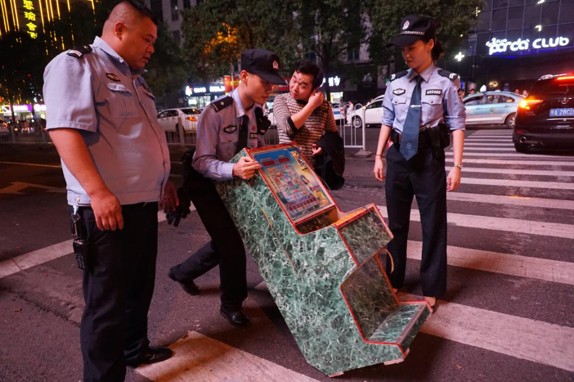 老虎机没有滚轮，民警们只好轮流将老虎机徒手从闹市区推回所里。