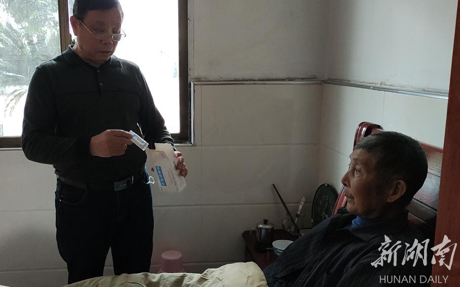 过鹿坪敬老院院长何盈庭正在询问老人身体状况。曾亚维 摄