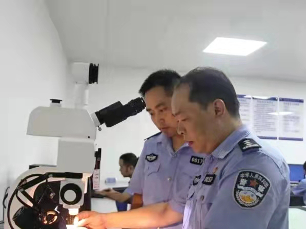 杨雄（右）在实验室比对指纹