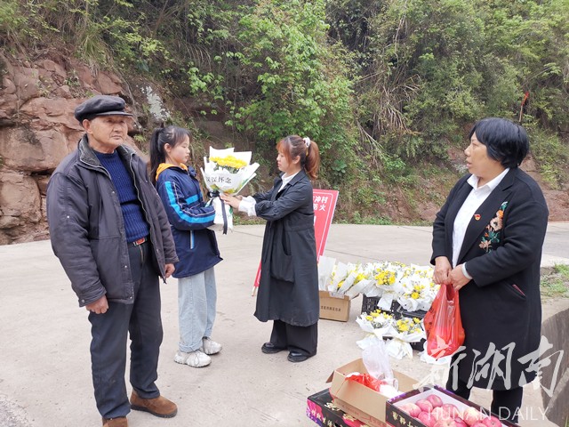 许积雄领着孙女在领取扫墓用的鲜花和祭品。李夏涛 摄