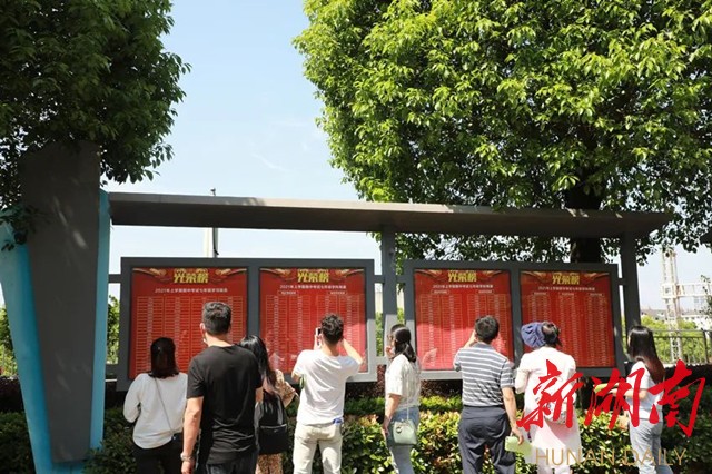 上图:学校光荣榜前,家长们纷纷驻足观看,寻找自家小孩的名字。 上图:学校光荣榜前,家长们纷纷驻足观看,寻找自家小孩的名字。