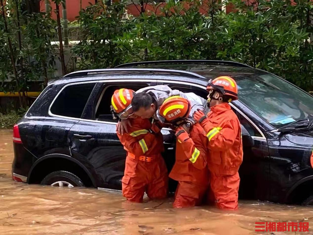 暴雨突袭5人被困,消防员雨中合力抬车救人