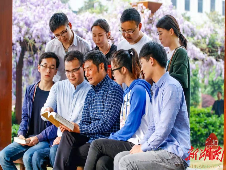 图为王诚喜和他的学生们在一起研究课题。 图为王诚喜和他的学生们在一起研究课题。