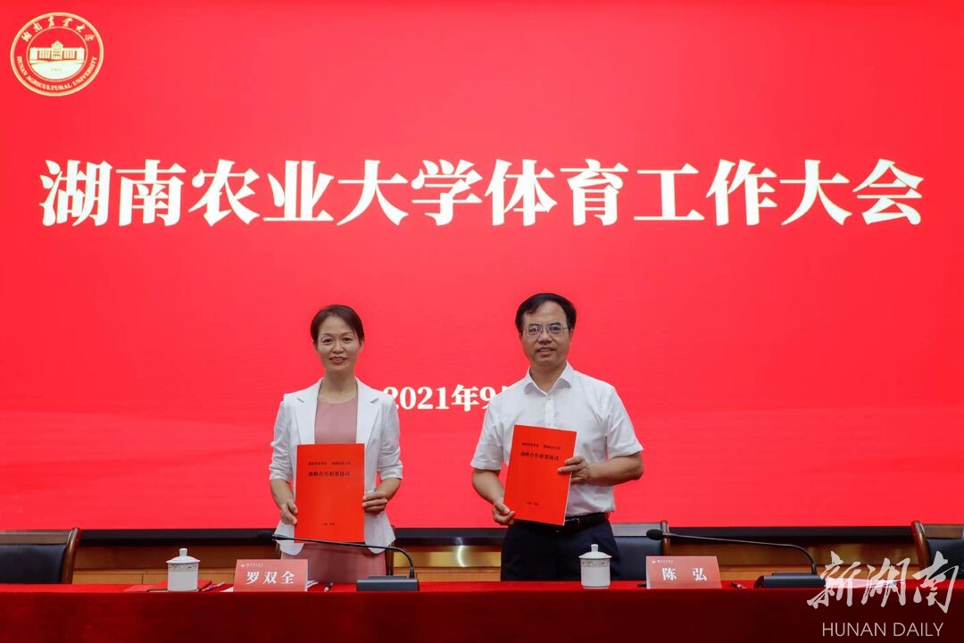 省体育局局长罗双全与湖南农业大学党委书陈弘展示合作框架协议书。 省体育局局长罗双全与湖南农业大学党委书陈弘展示合作框架协议书。