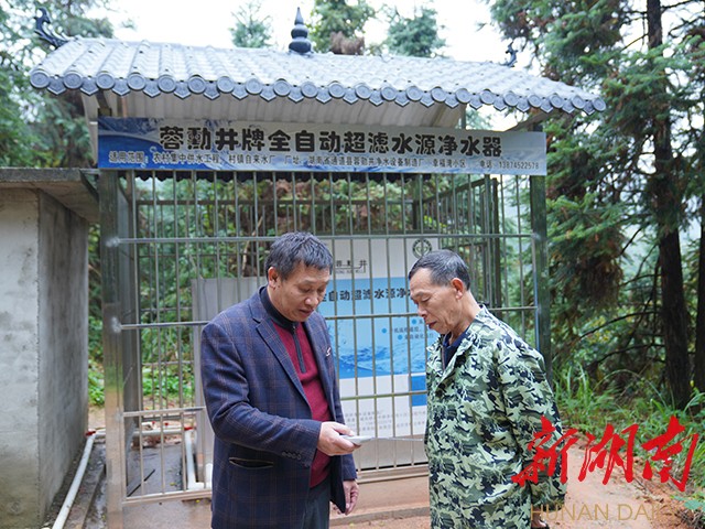 蒙勇（左）指导村民使用净水器