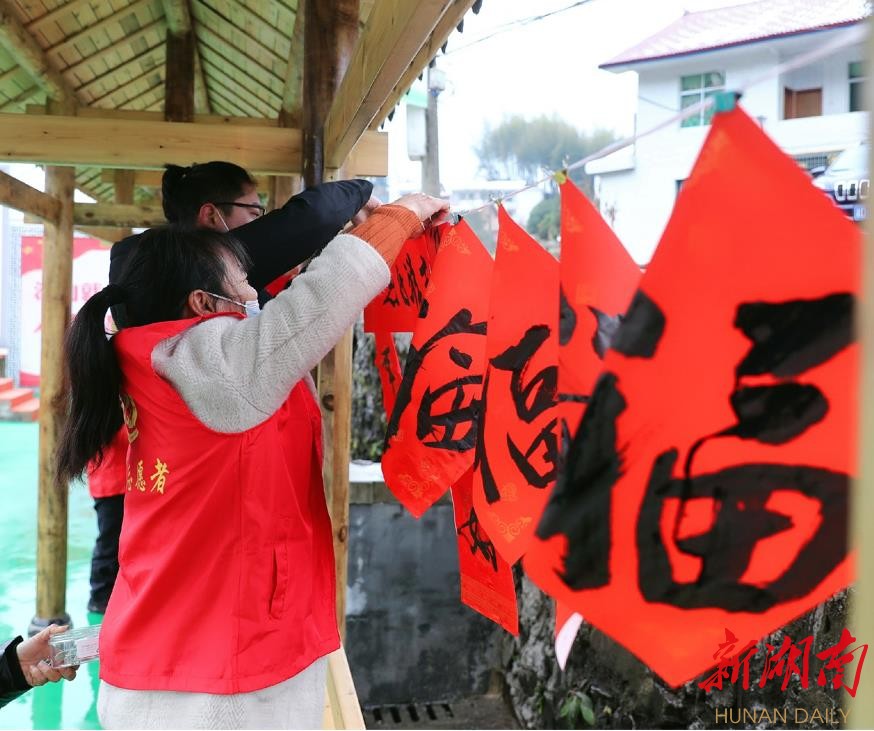 春节临近，沙田溪洋溢着欢乐、祥和的气氛。图为村民在风雨廊桥张挂“福”字。