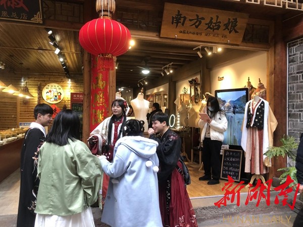 游客们穿者颜色各异、不同款式的苗服、汉服服装在凤凰古城拍照