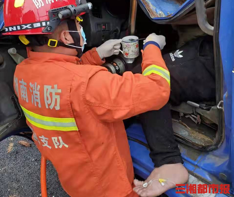 吊車撞翻水渠司機被困消防員一邊救援一邊喂水