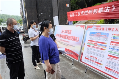 普法宣传展板吸引市民围观学习。