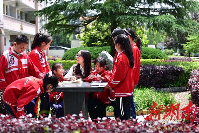 李柏霖将诗歌课堂搬到教室外，让孩子们与大自然对话,亲身去感受周边的世界。朱毅 甄叙斐 摄 