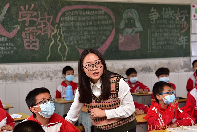 在诗歌教学课堂上，李柏霖在指导孩子们写诗。朱毅 甄叙斐 