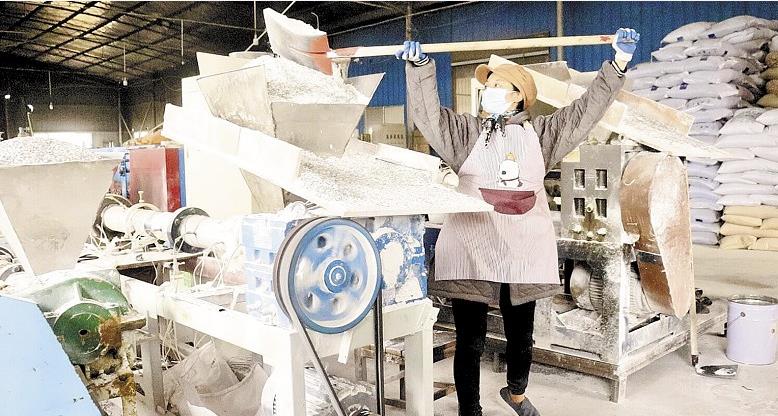 工作人员将废旧农膜粉碎形成的颗粒投入塑化机。 工作人员将废旧农膜粉碎形成的颗粒投入塑化机。