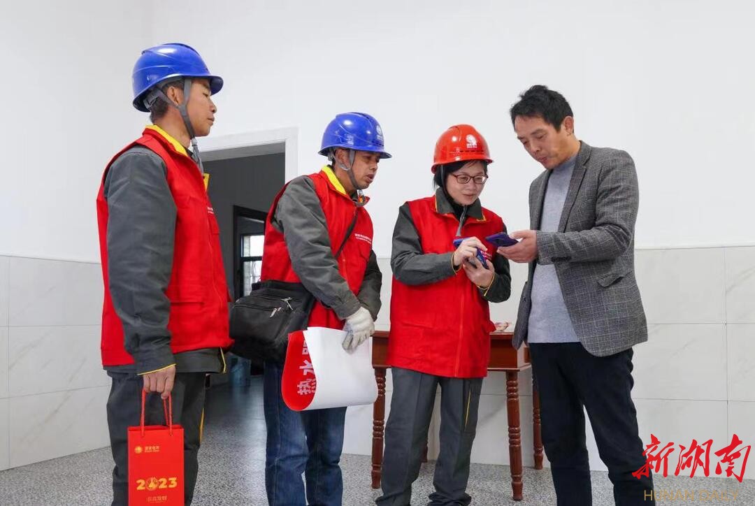 国网衡阳供电公司工作人员向返乡人员推广“网上国网”APP。(张雁 摄) 国网衡阳供电公司工作人员向返乡人员推广“网上国网”APP。(张雁 摄)
