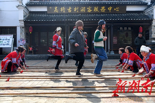 在高椅古村,游客体验跳竹竿舞。杨智伟 摄 在高椅古村,游客体验跳竹竿舞。杨智伟 摄