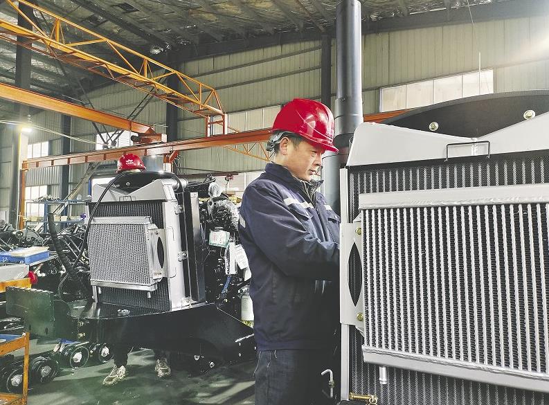 富佳科技公司的工人对履带拖拉机进行出厂检验。