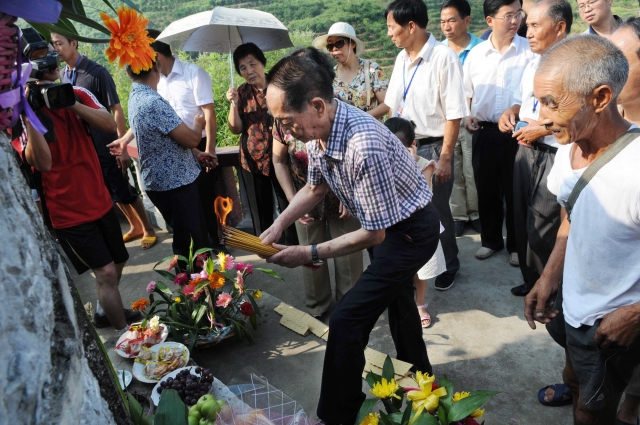 【2010年8月，袁隆平院士、邓则老师率家人祭拜母亲。杨锡建 摄】