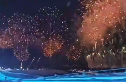 女子在冰雪大世界大滑梯上巧遇亚冬会开幕式烟花