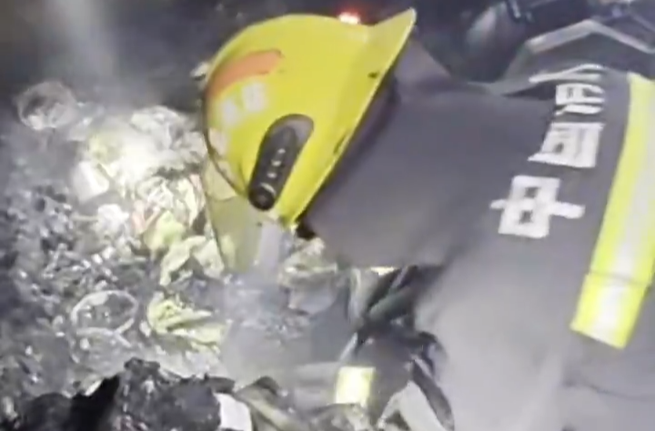 扑灭明火后，消防员俯身翻扒滚烫灰烬，为老人搜寻养老钱