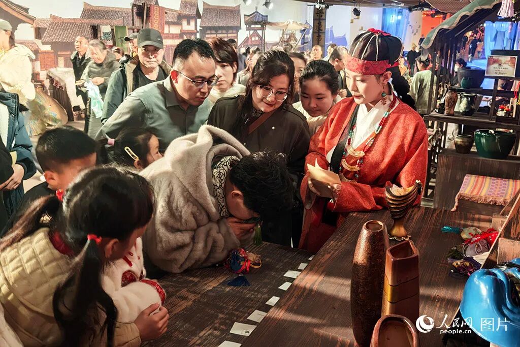 2026年2月20日，游客在宁夏银川市西夏陵景区与工作人员互动。近日，《西夏乐集》行浸式演艺在西夏陵景区启幕，作为我国第60项世界遗产所在地，春节期间西夏陵景区推出“文旅+演艺”旅游消费新场景，以独特的体验模式，让游客在行走间穿越古今，感受多民族融合的美好图景。人民网记者 阎梦婕摄