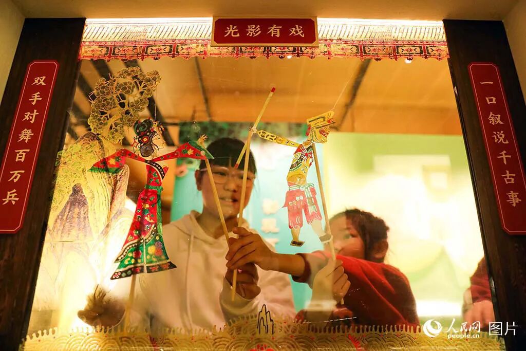 2026年2月20日，在山西博物院青铜分馆举办的“光影有戏——山西博物院藏清代皮影精品展”上，孩子们手拿皮影道具模拟演出效果。现场众多的皮影文物让观众共赏传统艺术的独特魅力，领略民间艺术的匠心技艺与民俗底蕴。人民网记者 王帆摄