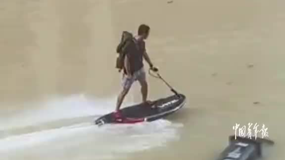 踏“浪”而来！朋友小区被淹物资紧张，男子骑动力冲浪板为其送物资