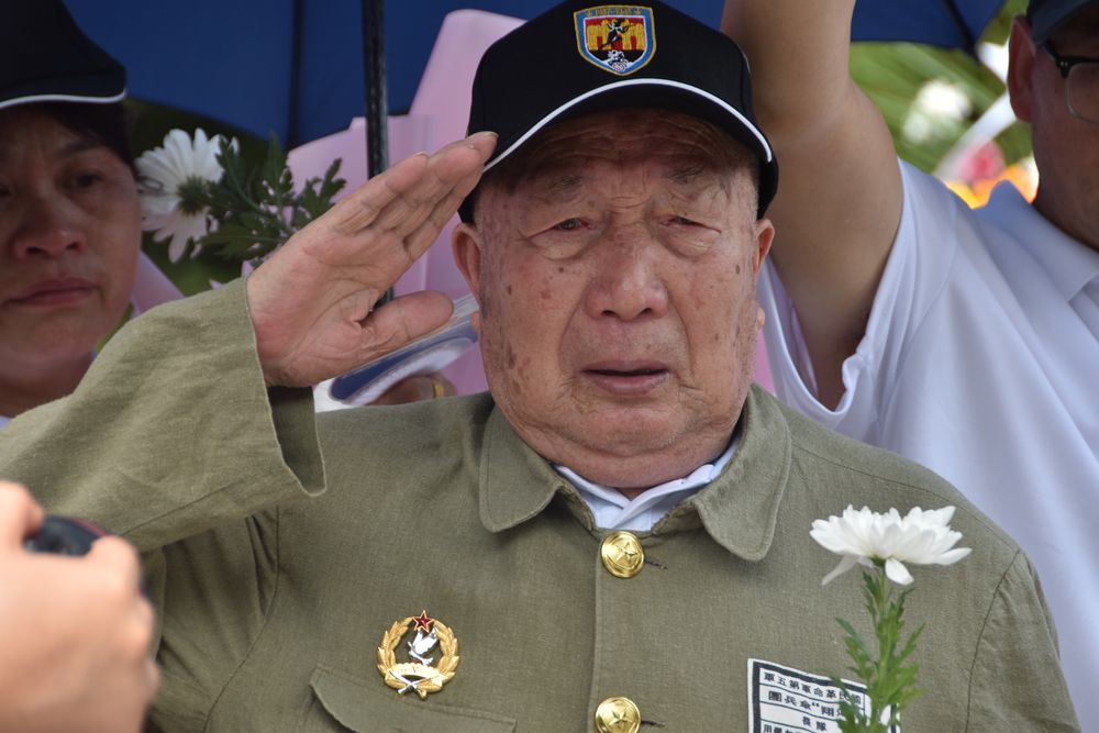 湖南省衡阳县,抗战老兵谢慈友向重新下葬的遗骸敬礼.