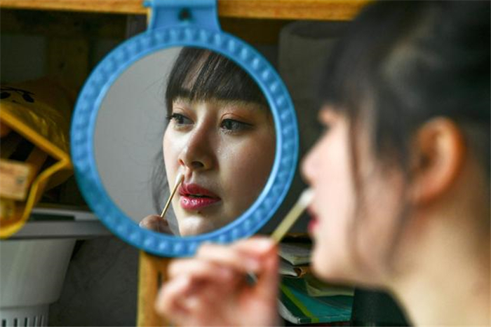 袁小梅在检查蜂箱时不慎被蜜蜂蛰伤鼻子,露出痛苦的神情(4月28日摄