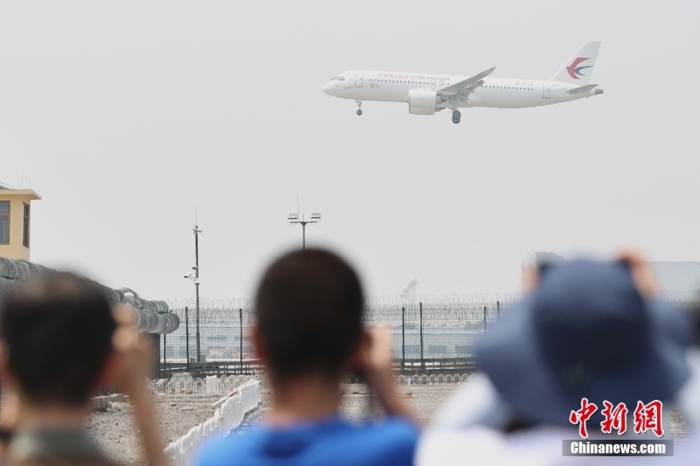 5月28日，自上海虹桥国际机场起飞的东航MU9191航班平安降落在北京首都国际机场，标志着中国国产大飞机C919圆满完成首个商业航班飞行。图为民众在北京观看MU9191航班降落。  中新社记者 蒋启明 摄